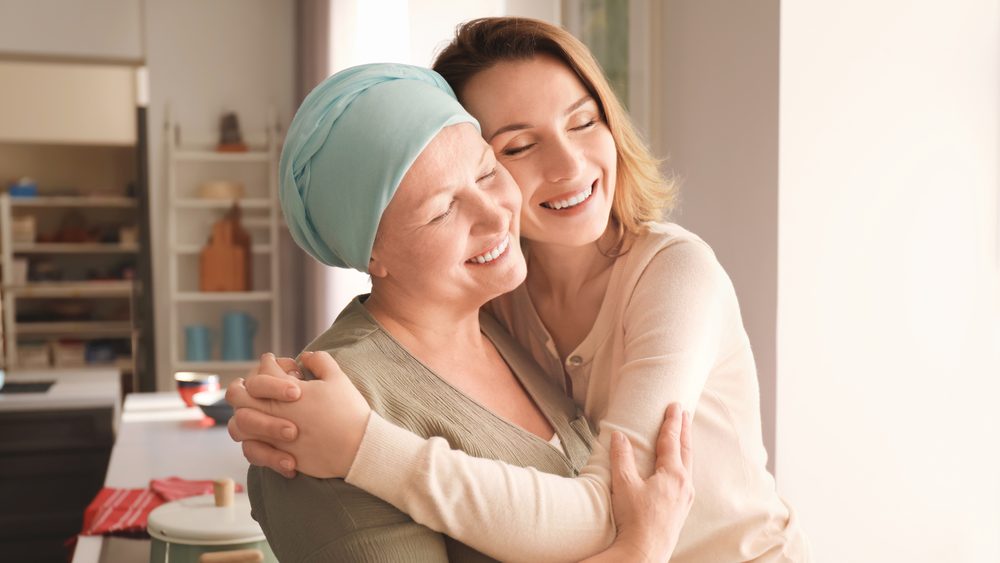 A woman comforting a friend going through cancer treatment