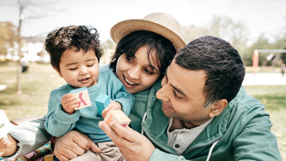 A young family outdoors with their child